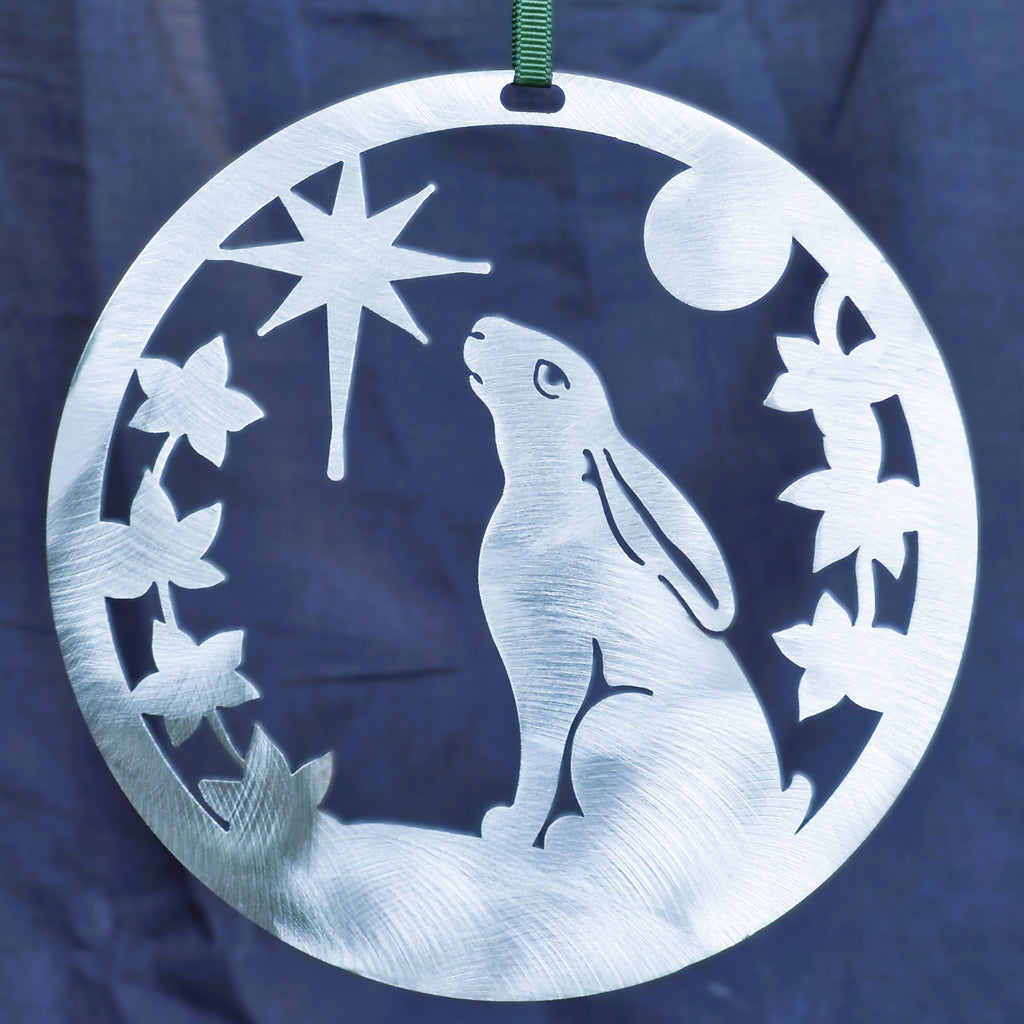 Polished silver Christmas Hare ornament against a dark navy background