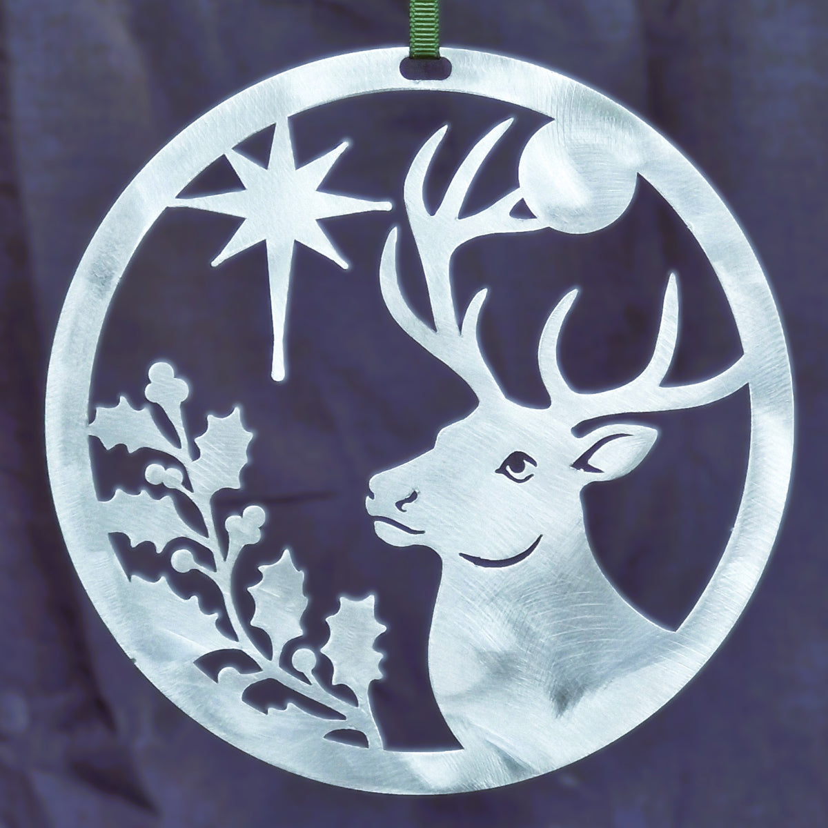 Polished silver Christmas Stag ornament against a dark navy background