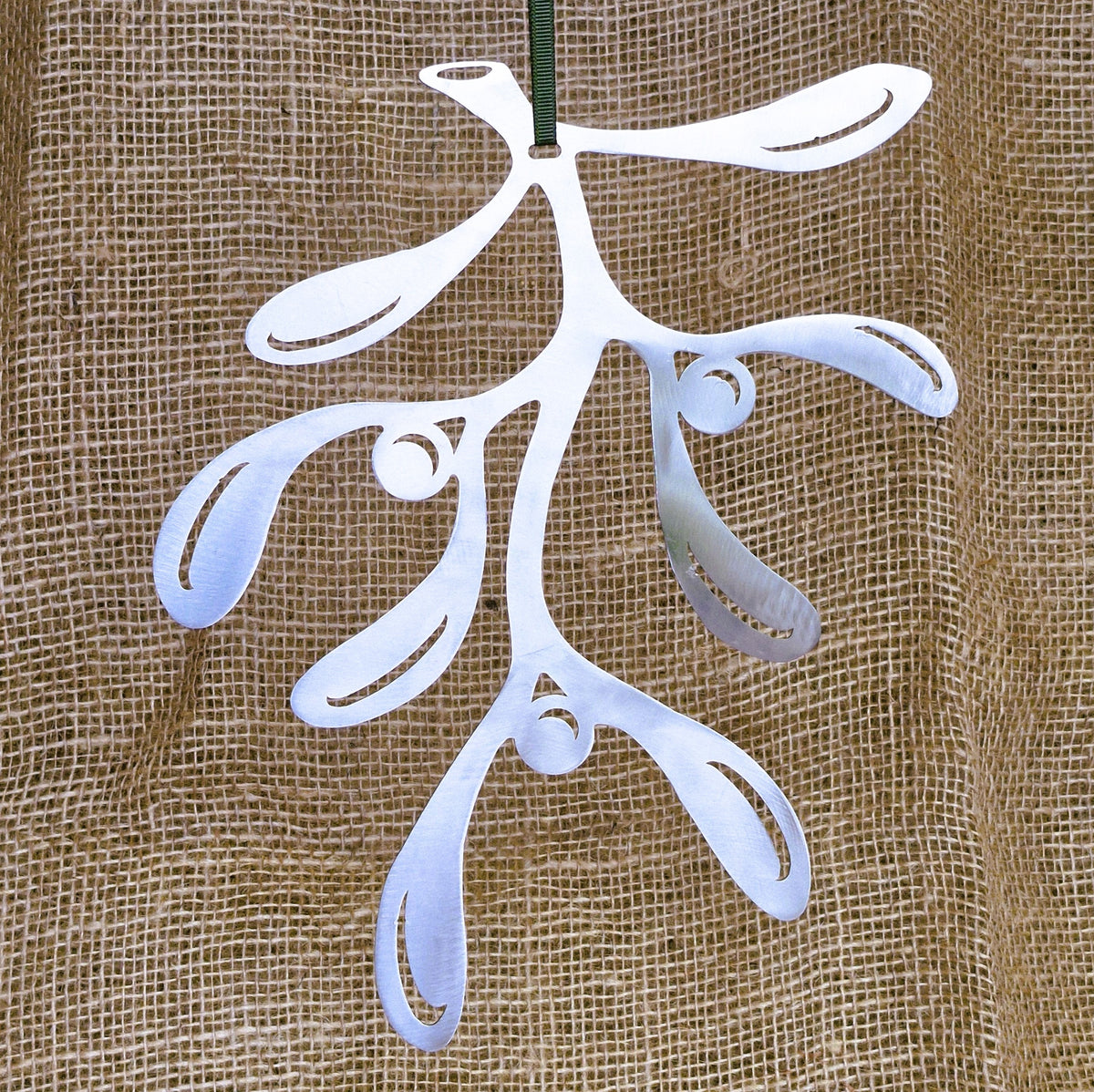 Stainless steel mistletoe decoration against a hessian background