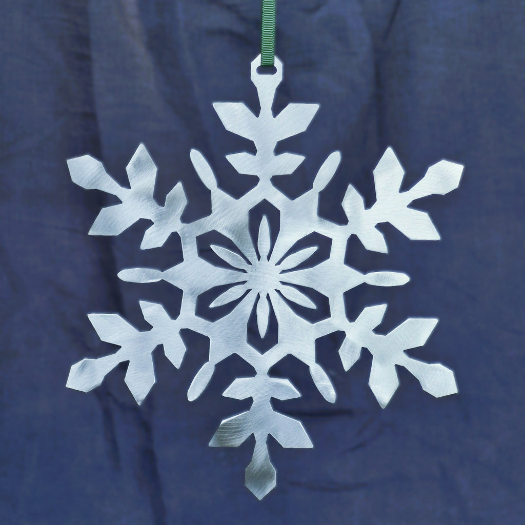Polished silver Christmas Snowflake ornament against a dark navy background
